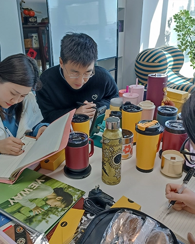 OEM design team developing custom cola shape stainless steel water bottle for wholesale production