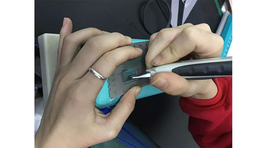 Detailed view of ISO 2409 cross-cut adhesion test ensuring powder coating durability.