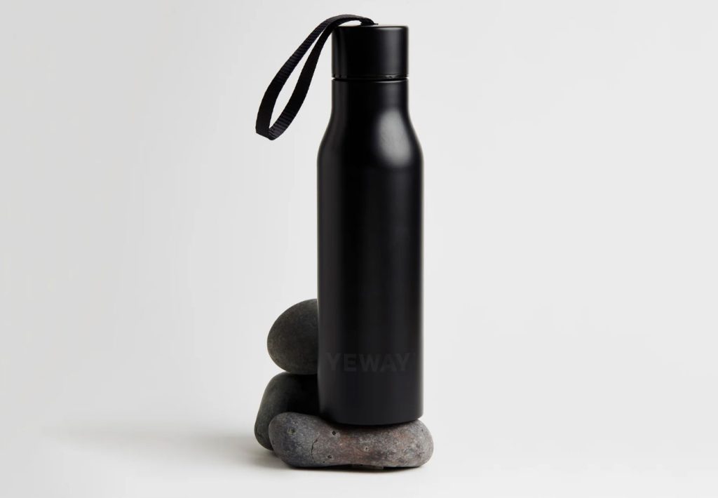 Bespoke minimalist water bottle in a modern office setting, showcasing premium aesthetic.